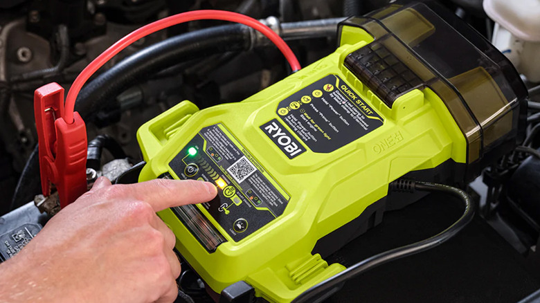 A person using a Ryobi Jump Starter to start their car