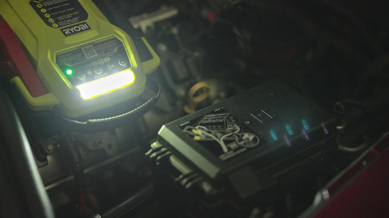 A Ryobi Jump Starter lighting an engine bay