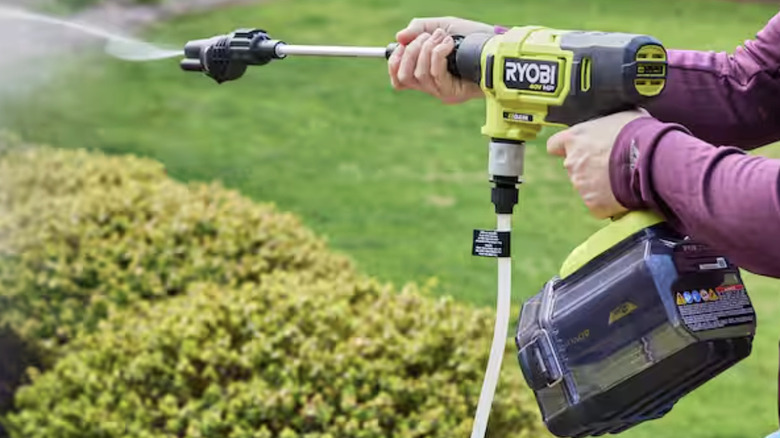 A person using the Ryobi EZClean Cordless Power Cleaner in their yard