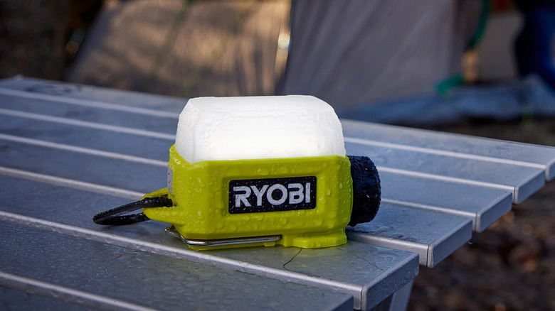 Ryobi USB Lithium area light on an outdoor table in the rain