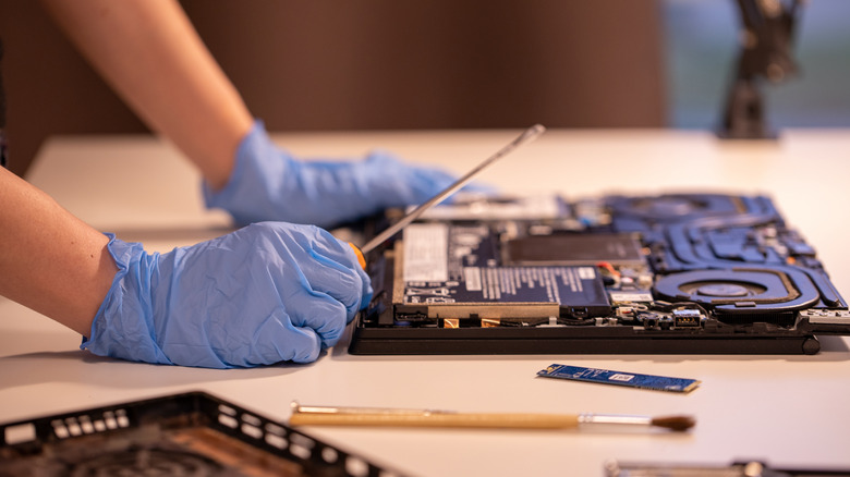 Person repairing a laptop