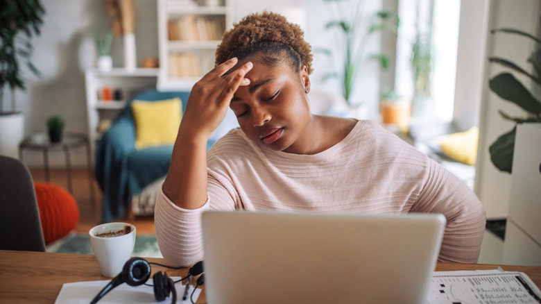Person working at a laptop frustrated