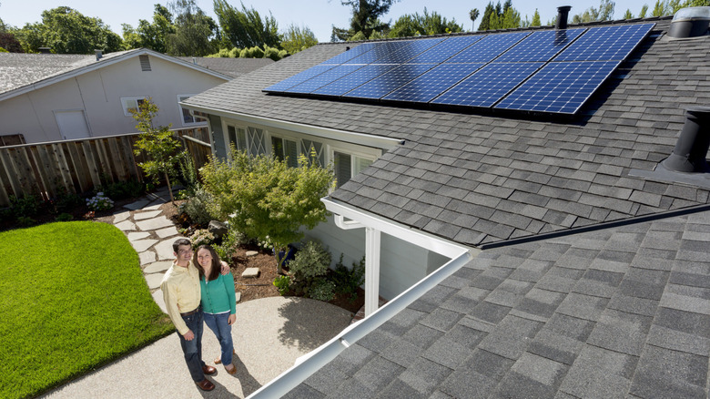 Couple standing next to house with solar panels