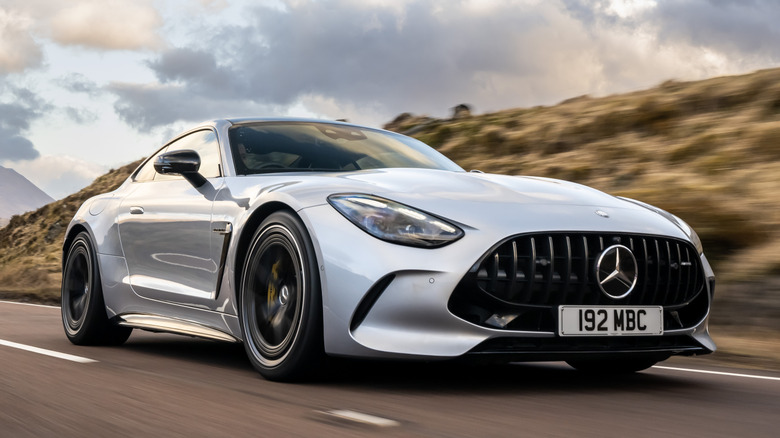 Front 3/4 view of Mercedes-AMG GT 63 Coupe on road with mountains in background