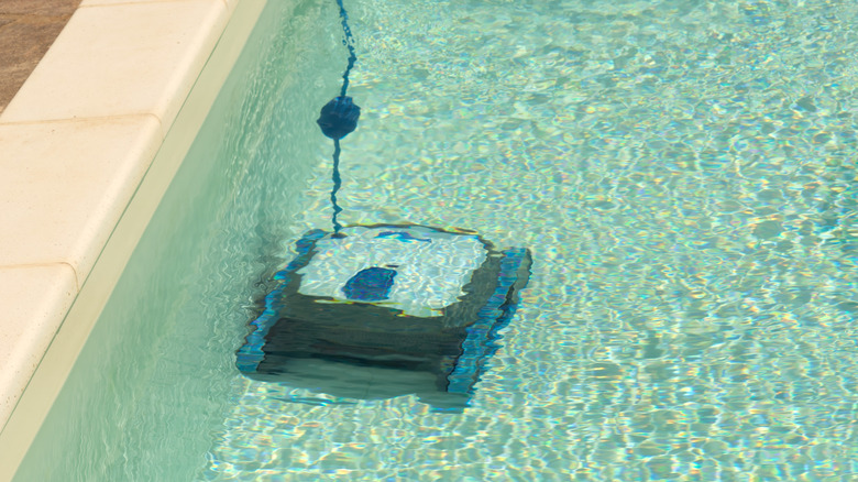 A robot pool cleaner vacuuming the bottom of the pool.