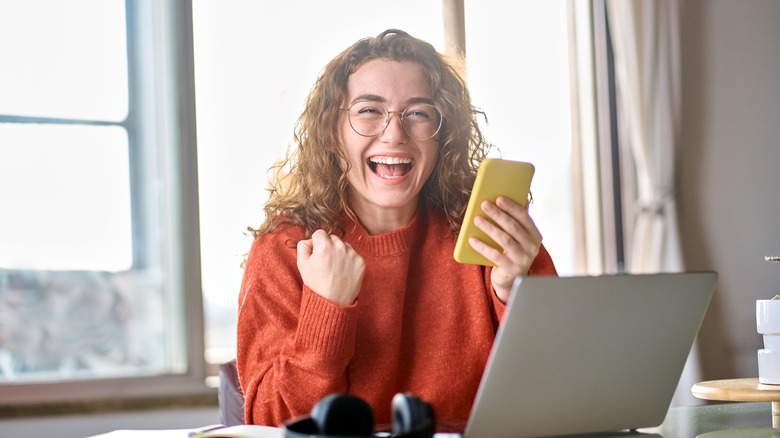 Woman smiling and unboxing phone