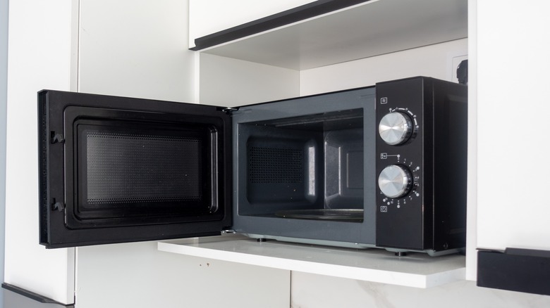 Black microwave oven with the door open.