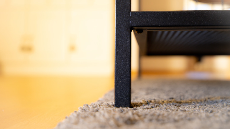 Pictures showing the leg of a table causing a divot in a rug.
