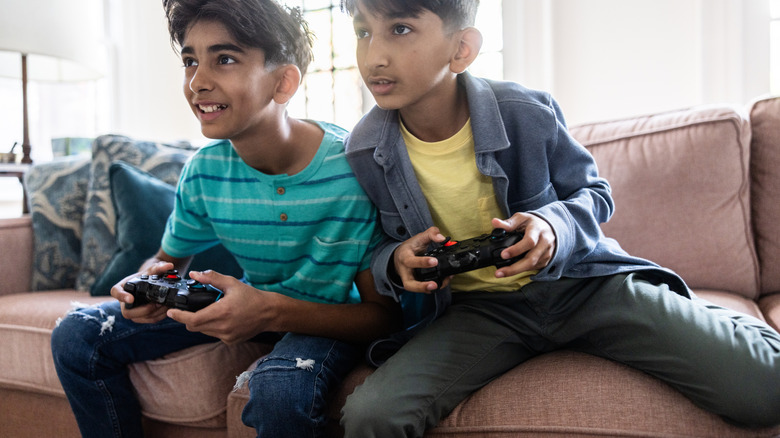Kids on the couch holding wireless game controllers