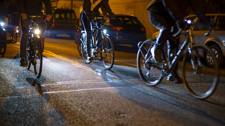 Cyclists biking with lights at night