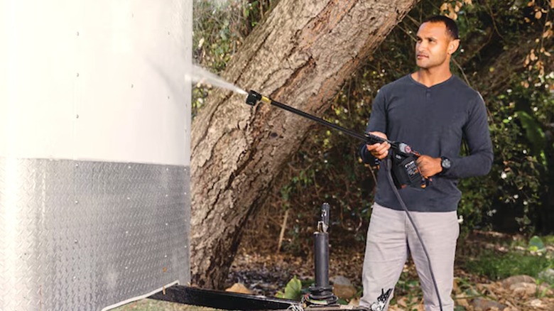 Person cleaning a trailer with a pressure washer