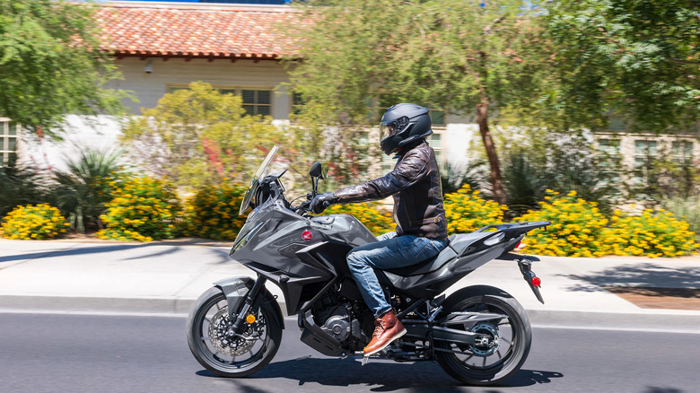 Man riding Honda touring bike in residential neighborhood.