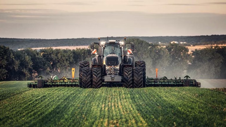 Person driving a Valtra tractor in a field
