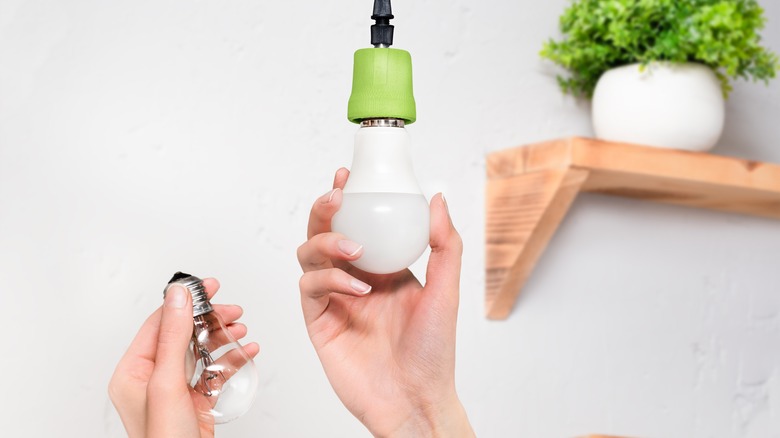 woman changing light bulb