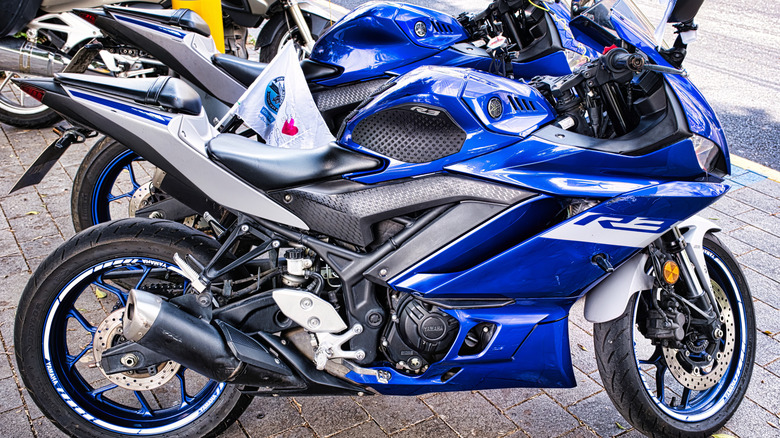 Two blue Yamaha R3 motorcycles parked, side view