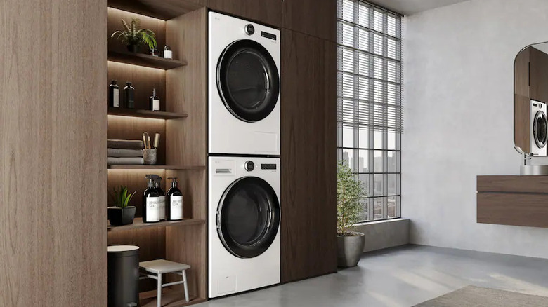 A white LG washer and dryer set stacked in a modern laundry space