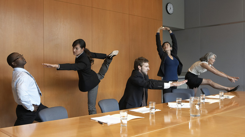 people stretching in office meeting room