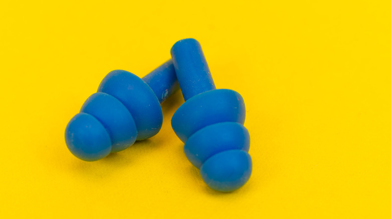 blue earplugs on yellow background