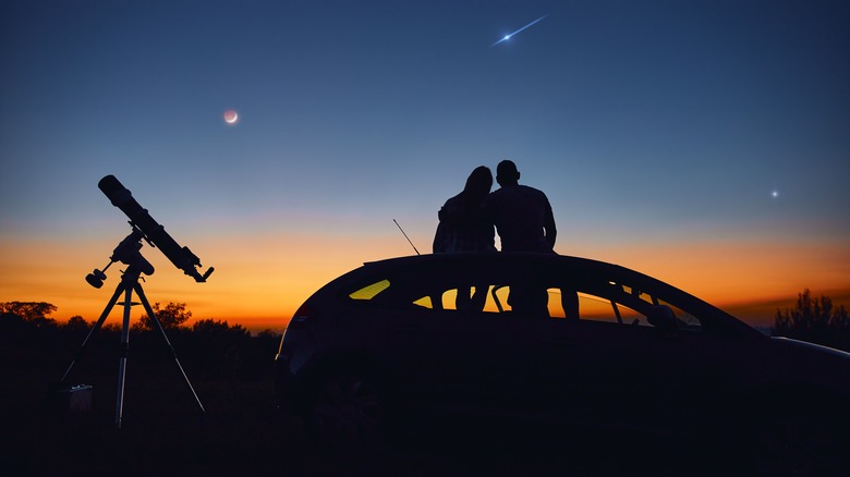 People silhouetted together against night sky