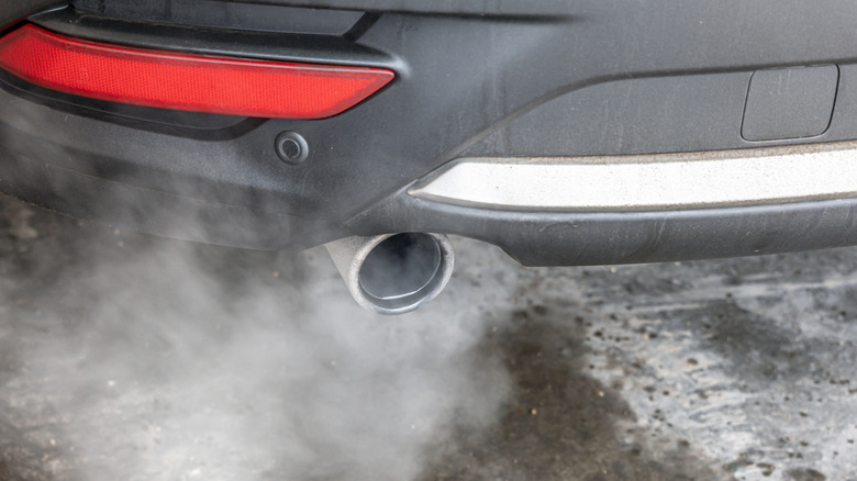 A close-up of a car exhaust pipe from an idling car