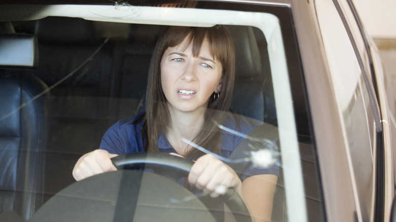 woman looking at windshield crack