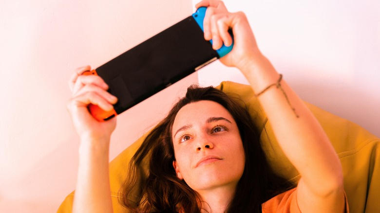 woman holding up a Nintendo Switch
