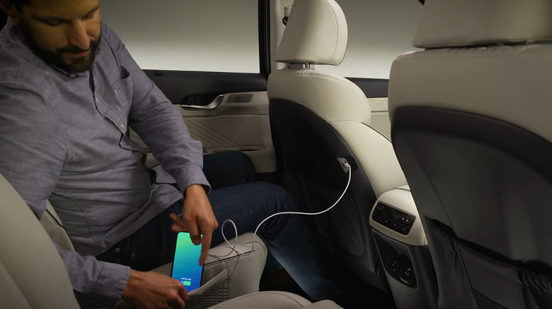 A man charging iPhone in car using USB cable
