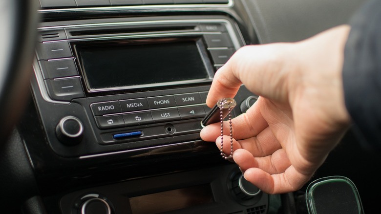 Hand inserting USB flash drive to car