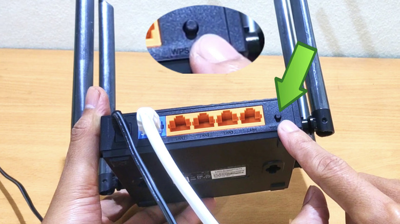 Man hits the reset button on a router