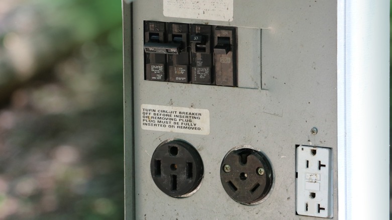 An RV park power pedestal with a selection of 120V plug ins, including 50 amp, 30 amp, and 20 amp service.