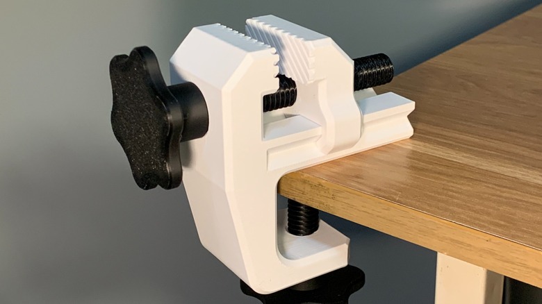 A black and white 3D printed vise on a table.