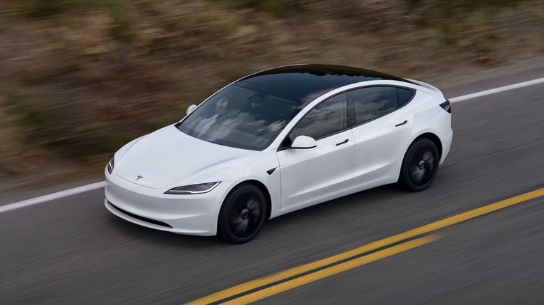 Tesla Model 3 driving on road, front 3/4 view, white exterior, high angle