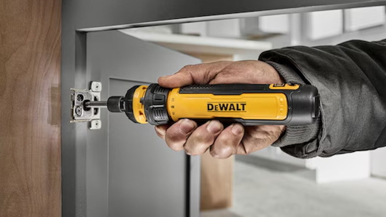 person using DeWalt Cordless Screwdriver with FlexDrive Control on door hinge