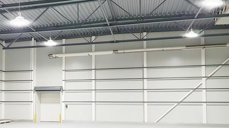 High bay light fixtures from JC-LGL installed in a large, white garage bay