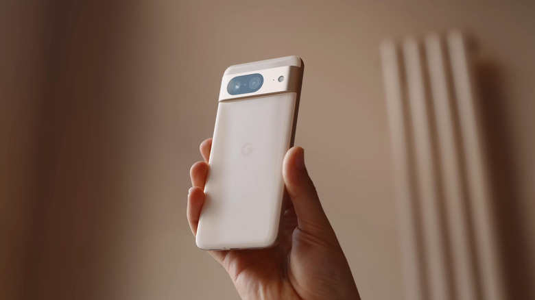 A Google Pixel 8 smartphone being held in a person's hand