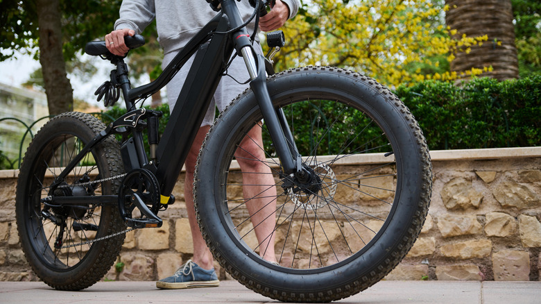 Person holidng electric bicycle.