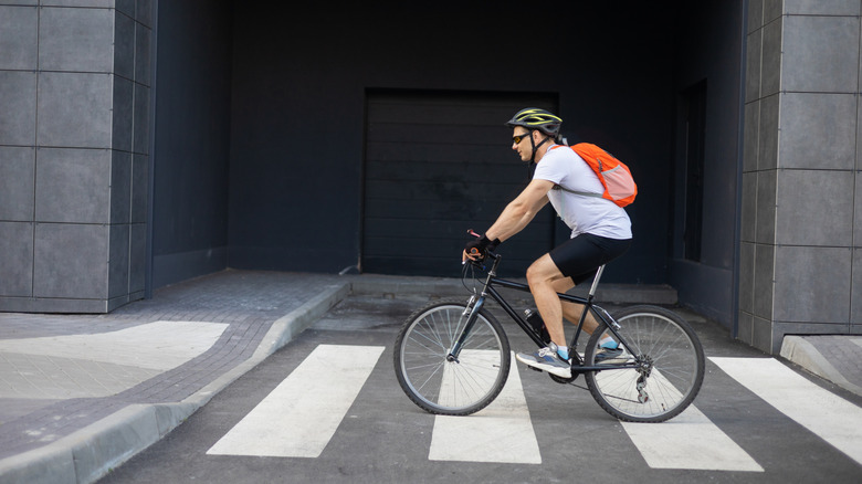 Person pedaling bicycle on a crossing.