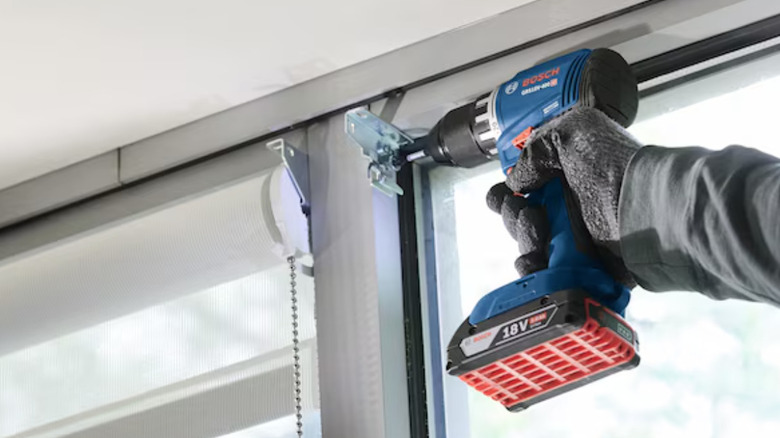 Bosch 18-volt compact brushless drill/driver at work on metal window
