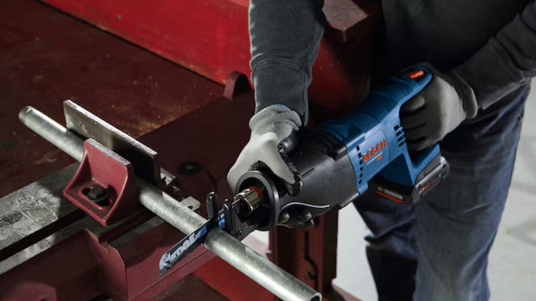 Bosch reciprocating saw being used on pipe in workshop