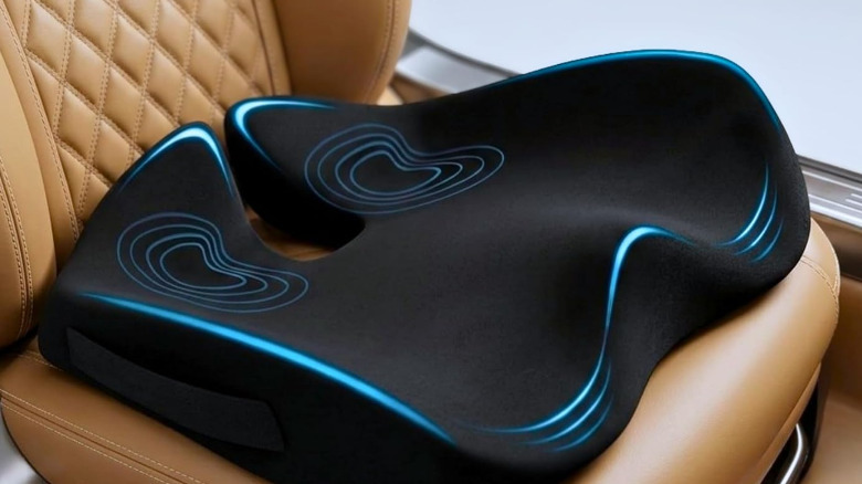 A black seat cushion on a brown car seat.