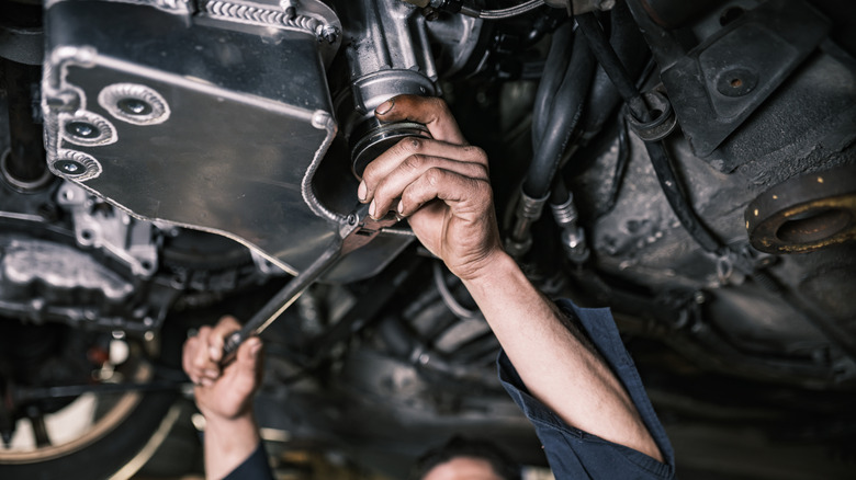 Man working on underside of vehicle