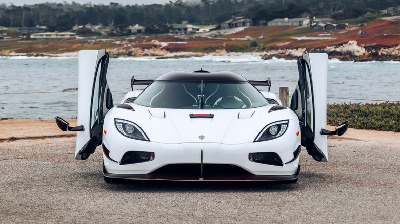 A white Koenigsegg Agera RS parked with its doors up.