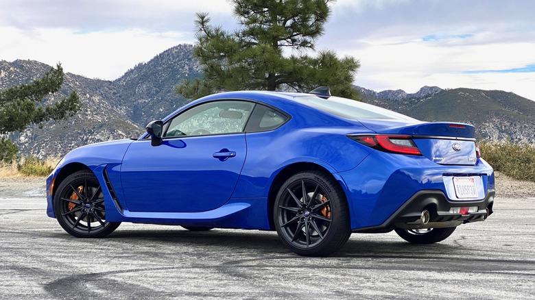 Blue Subaru BRZ parked with mountains in the background.