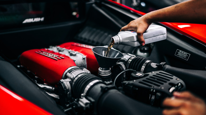 Pouring fresh oil into a Ferrari engine
