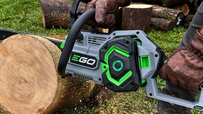 Close-up of a worker using an Ego Power Plus 18-inch chainsaw to cut a log