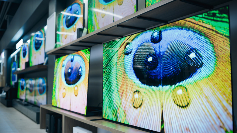 Wide-angle shot of multiple TVs on display at an electronics store