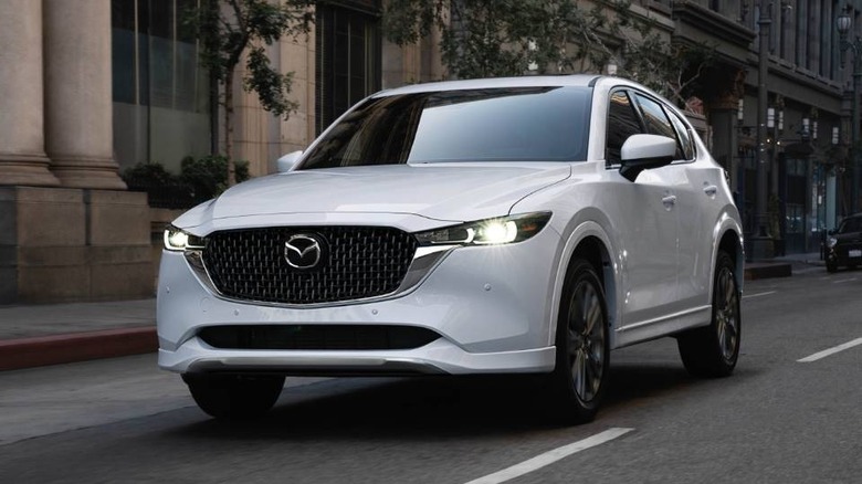 2025 Mazda CX-5 in white driving in city streets