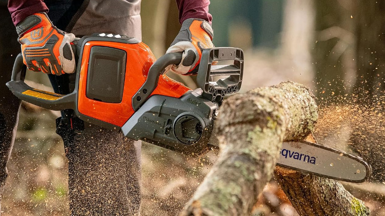 Glowed hands cutting wood with a Husqvarna 225i.
