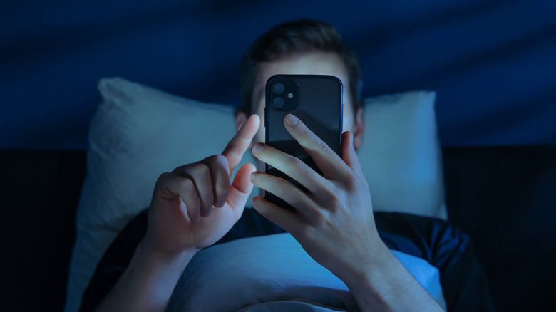 Person using a phone in bed.