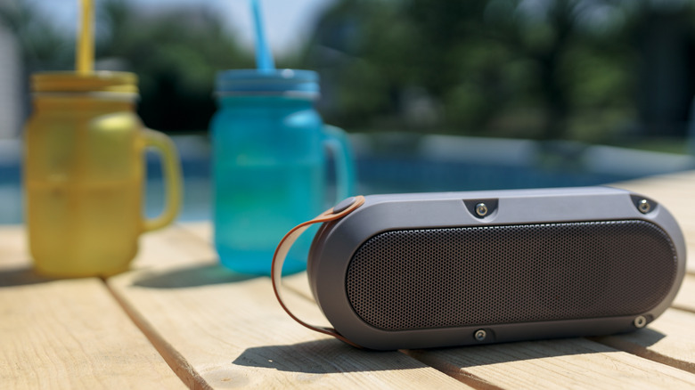 A Bluetooth speaker next to a pool.